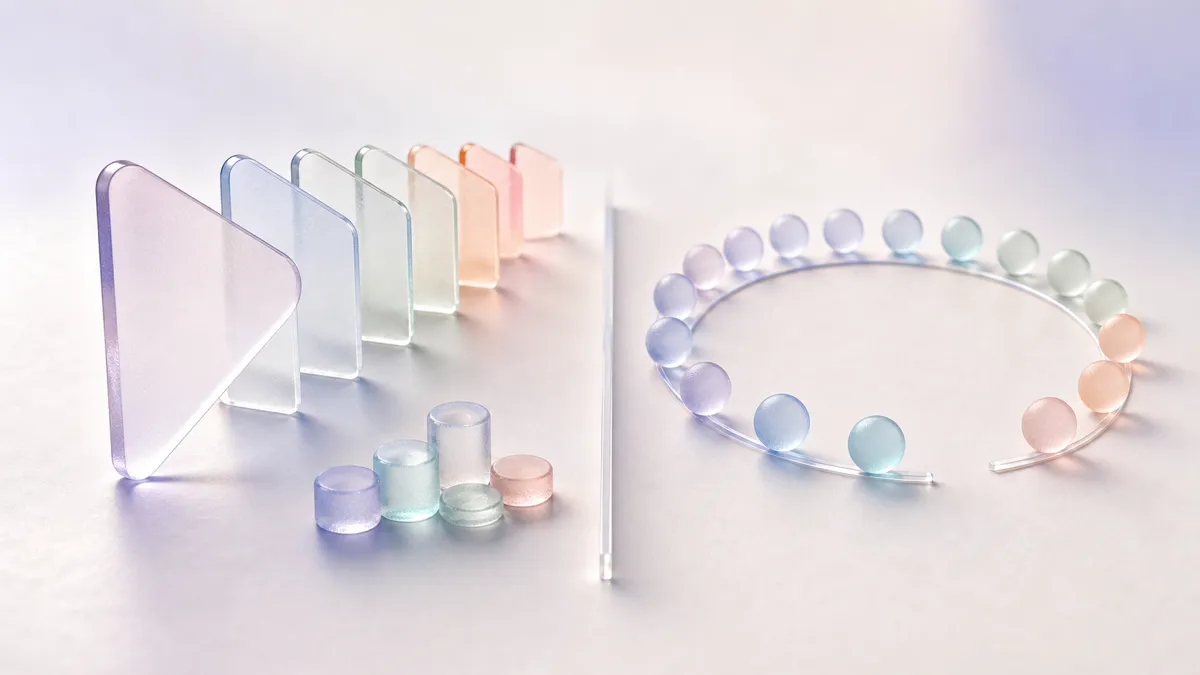 A glass play triangle beside a row of coloured panes and a ring of beads